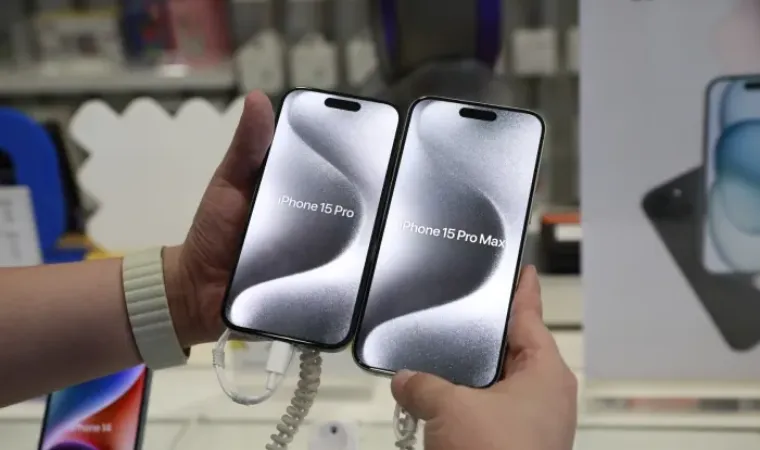 Imagem de uma pessoa segurando um iphone grande e um iphone normal para comparar os tamanhos