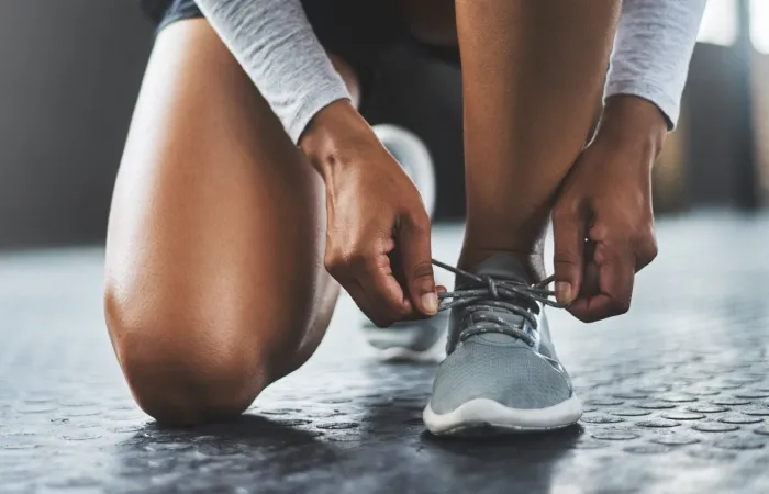 Mãos amarrando cadarço do tênis