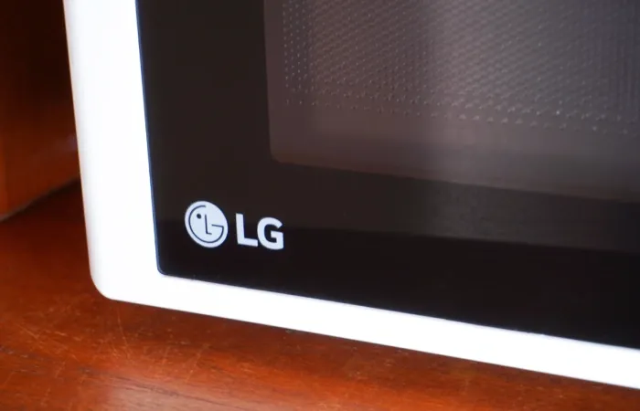 Destaque do microondas LG branco sobre bancada