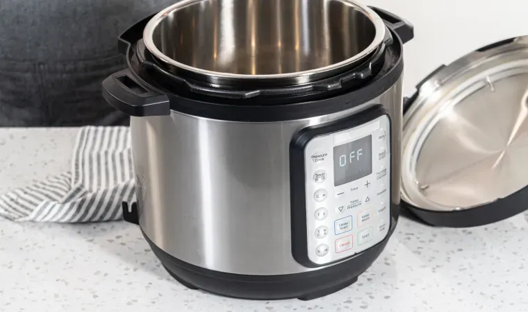 Panela de pressão elétrica desligada em bancada de cozinha.