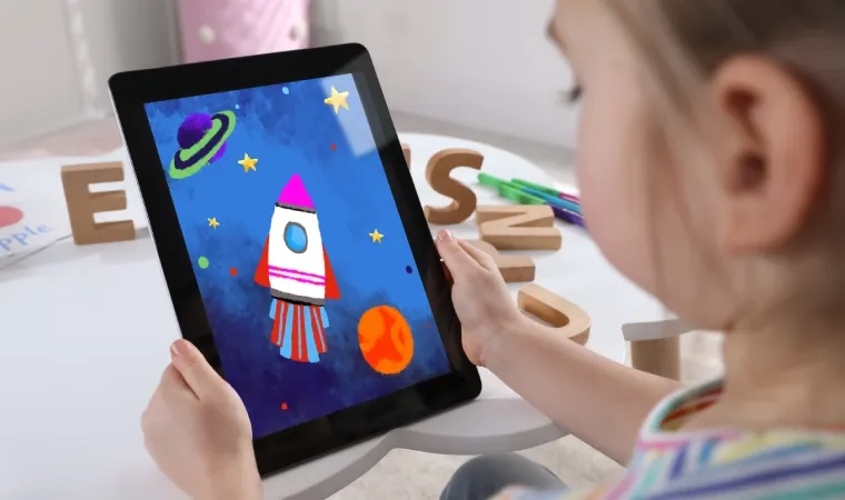 Menina em escola usando o seu tablet infantil para jogar