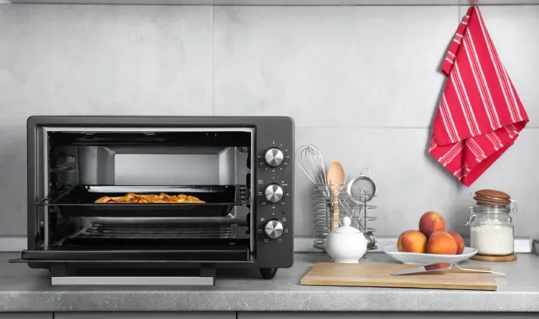 Forno elétrico aberto com alimento dentro.