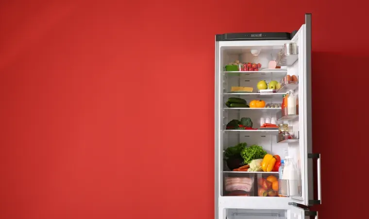 Geladeira custo-benefício aberta cheia de comida com parede colorida ao fundo.