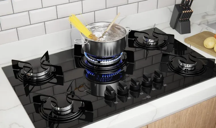 Panela com massa fervendo em cima de um fogão atlas.