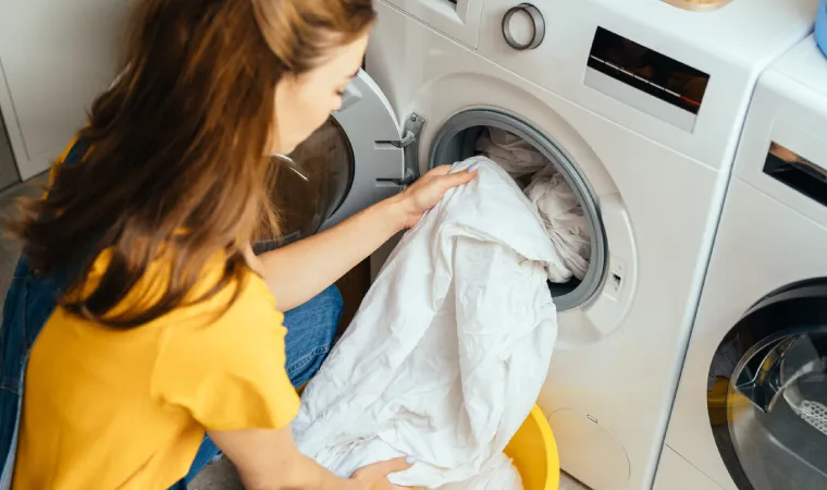 Mulher separando roupa na máquina de lavar