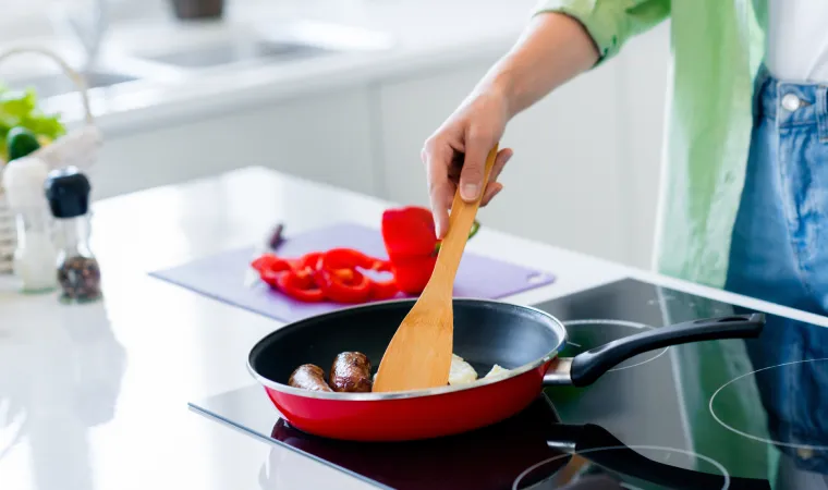 Pessoa cozinhando no fogão por indução