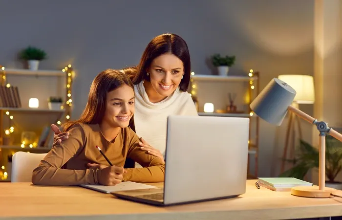 Mãe ensinando a filha a estudar em seu notebook para estudo