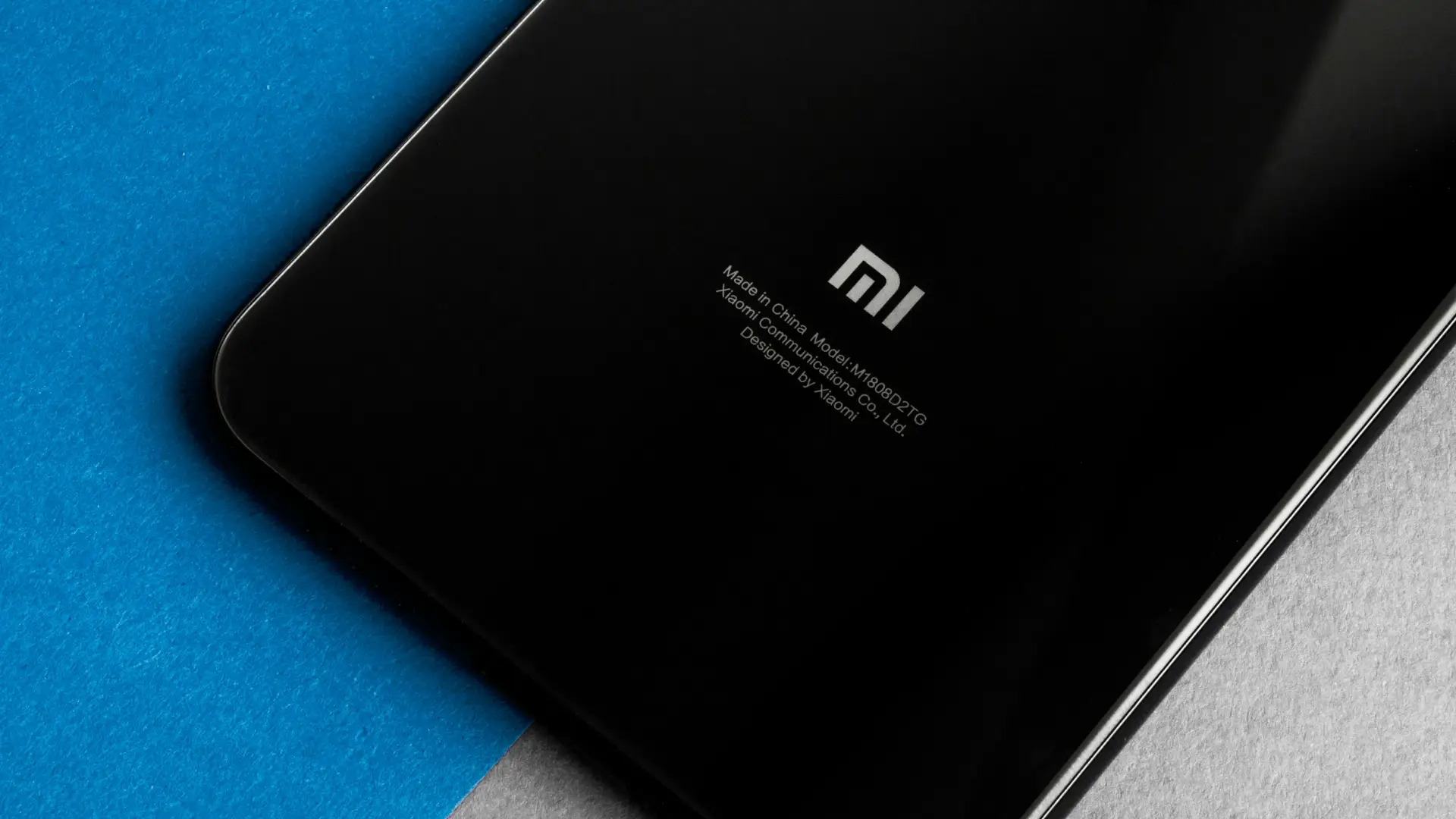 Imagem mostra um celular preto sobre uma mesa