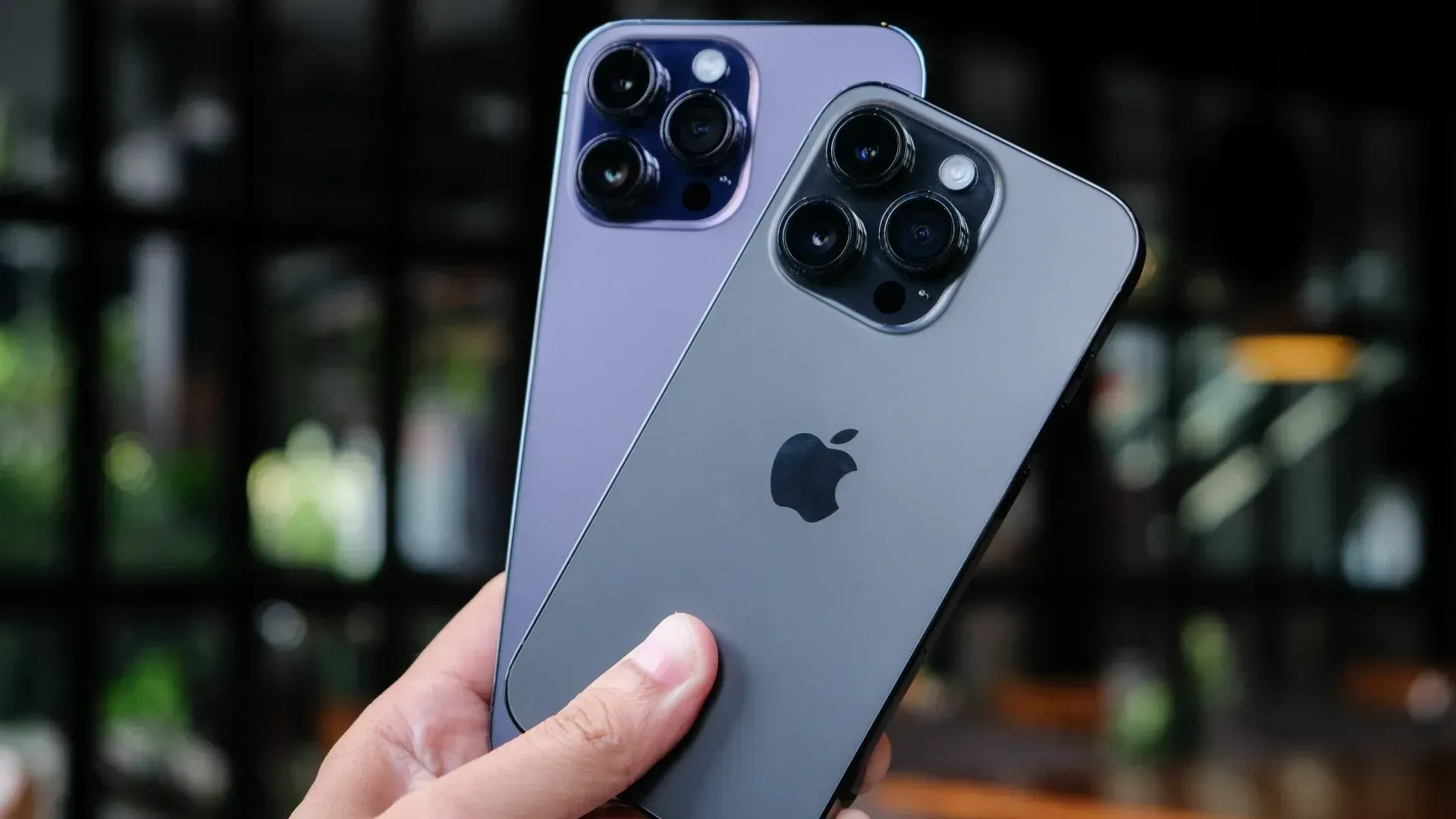 Dois iPhones na mão de usuário com fundo desfocado