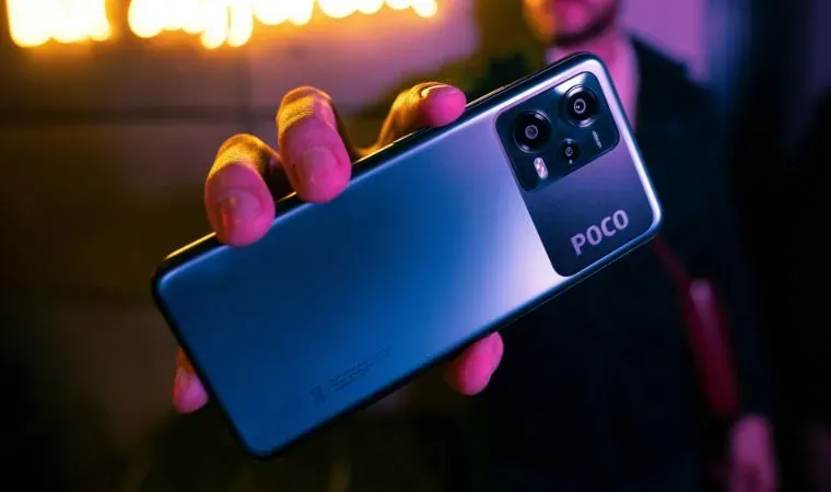 Um celular com a escrita pocophone está sendo segurado por uma pessoa 