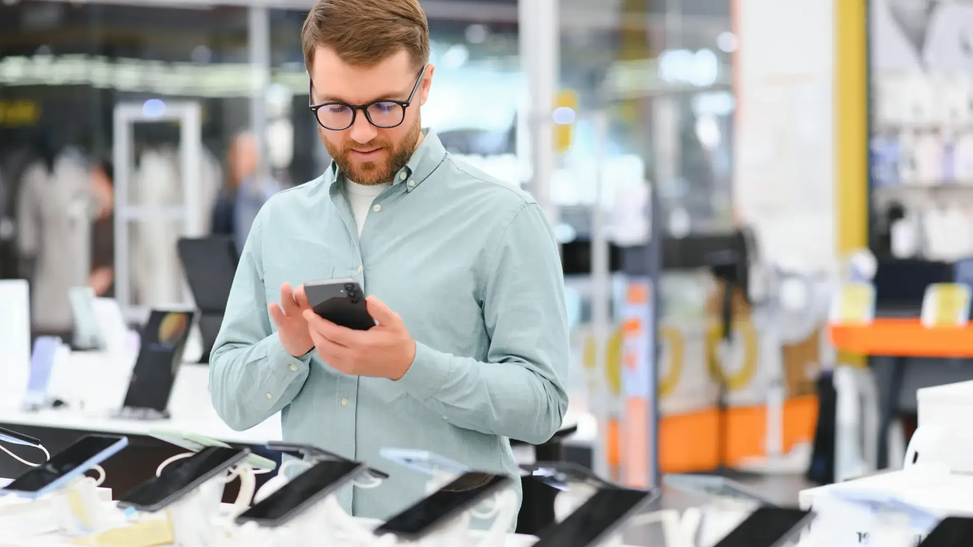 Homem escolhendo um celular bom e barato em loja