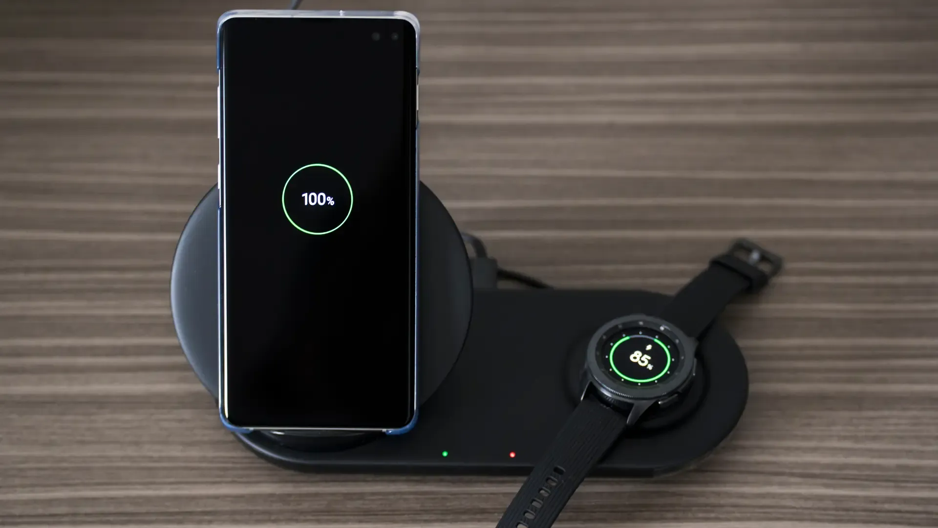 Um celular e um relógio estão sendo carregados em um carregador sem fio