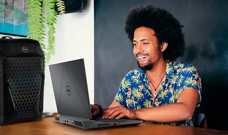 Foto de uma pessoa usando o notebook gamer Dell G15 sobre uma mesa de madeira 