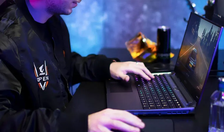 Foto de um jogador profissional jogando um game de corrida em um notebook gamer Gigabyte AORUS 5 