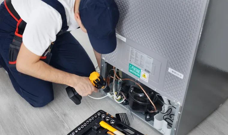  Técnico consertando a geladeira na cozinha. 