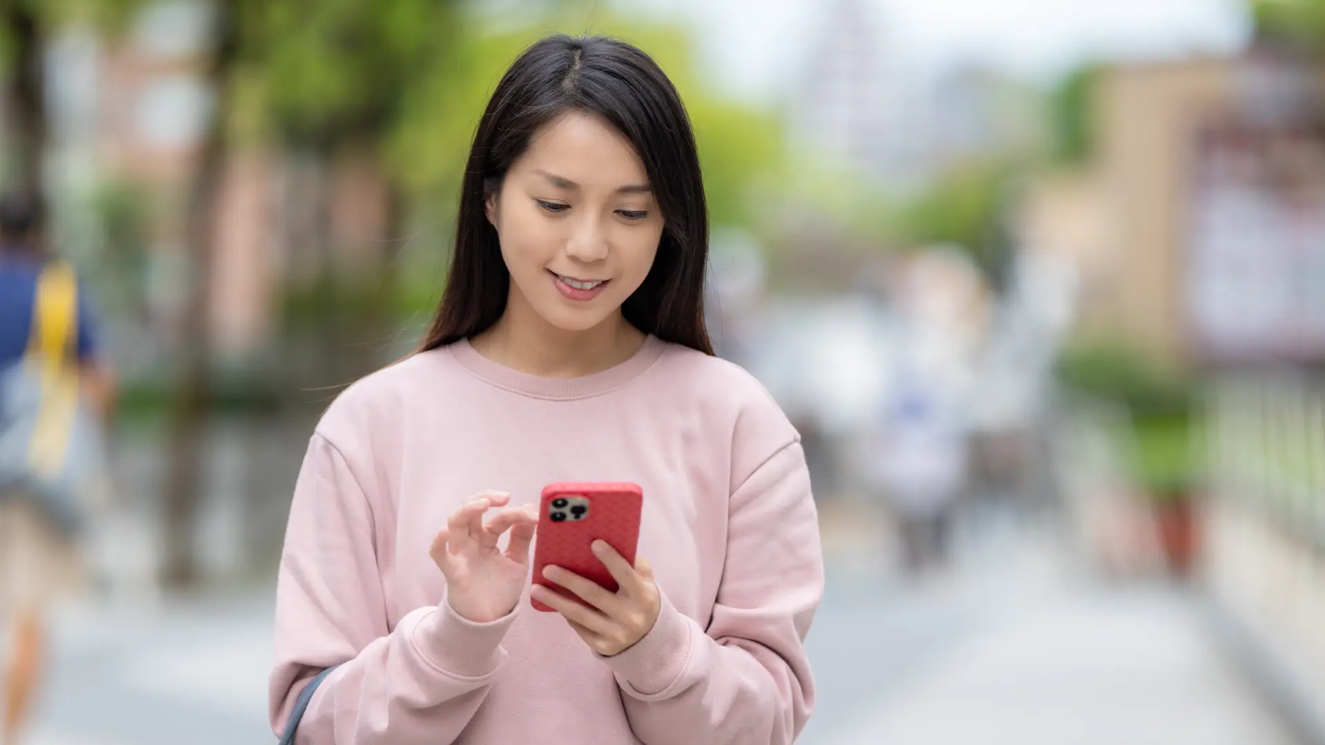 Mulher segura um telefone enquanto olha para a tela do aparelho