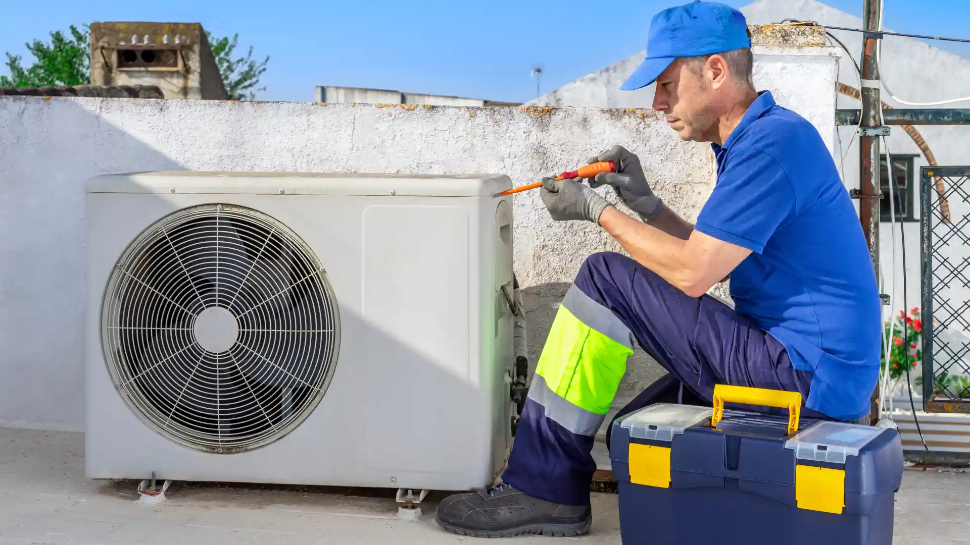 Imagem de um técnico sentando enquanto faz a manutenção em um ar-condicionado