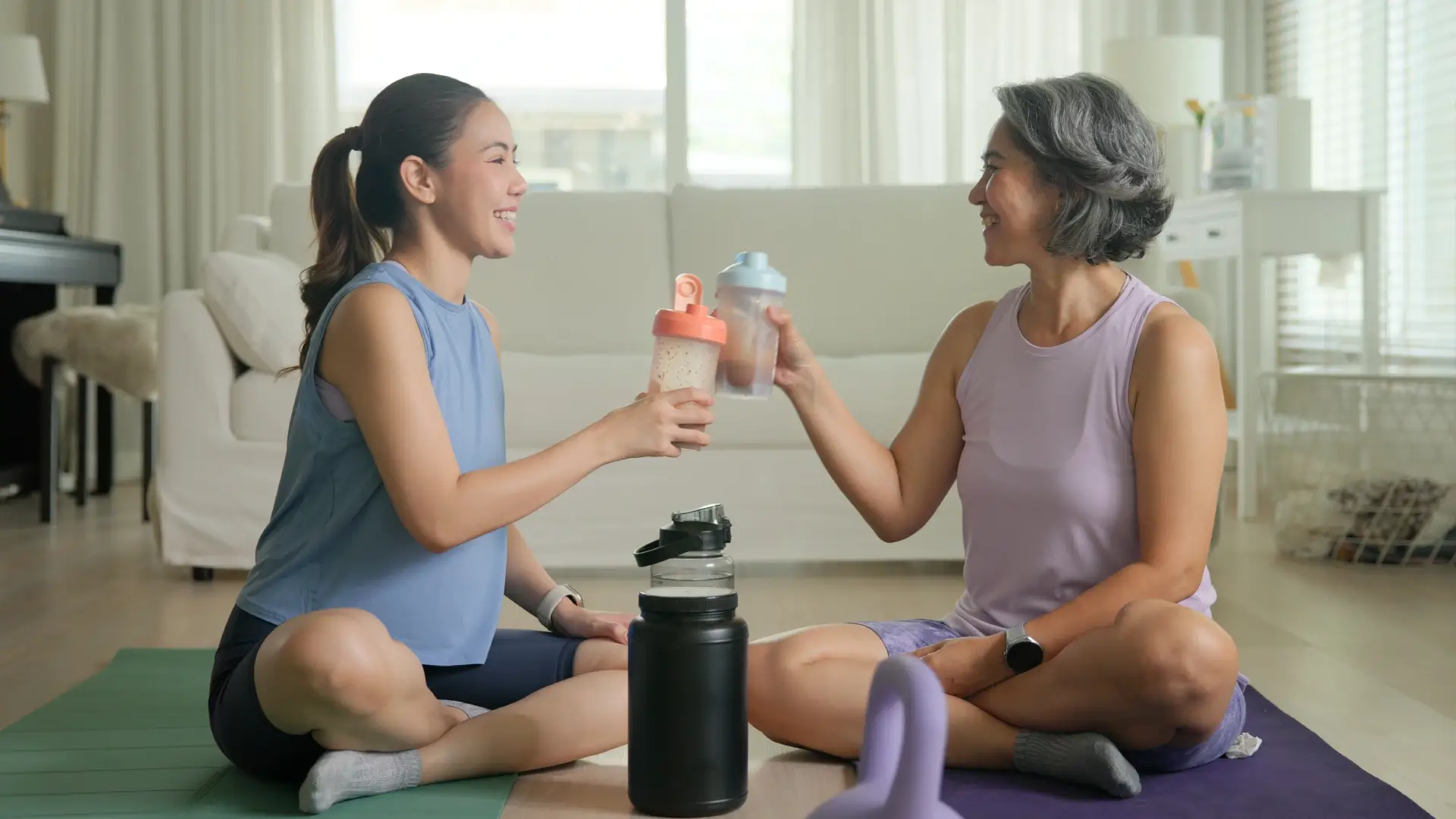 Jovem mulher e mulher madura brindando o copo de creatina 