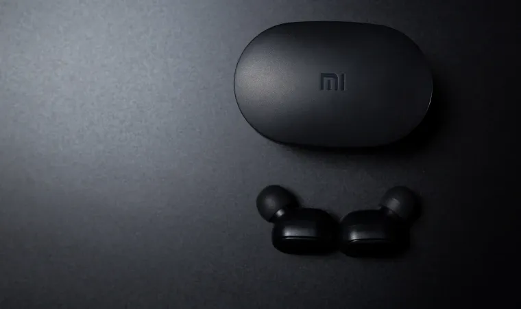 Fone Bluetooth Xiaomi logo abaixo da sua caixinha em fundo preto