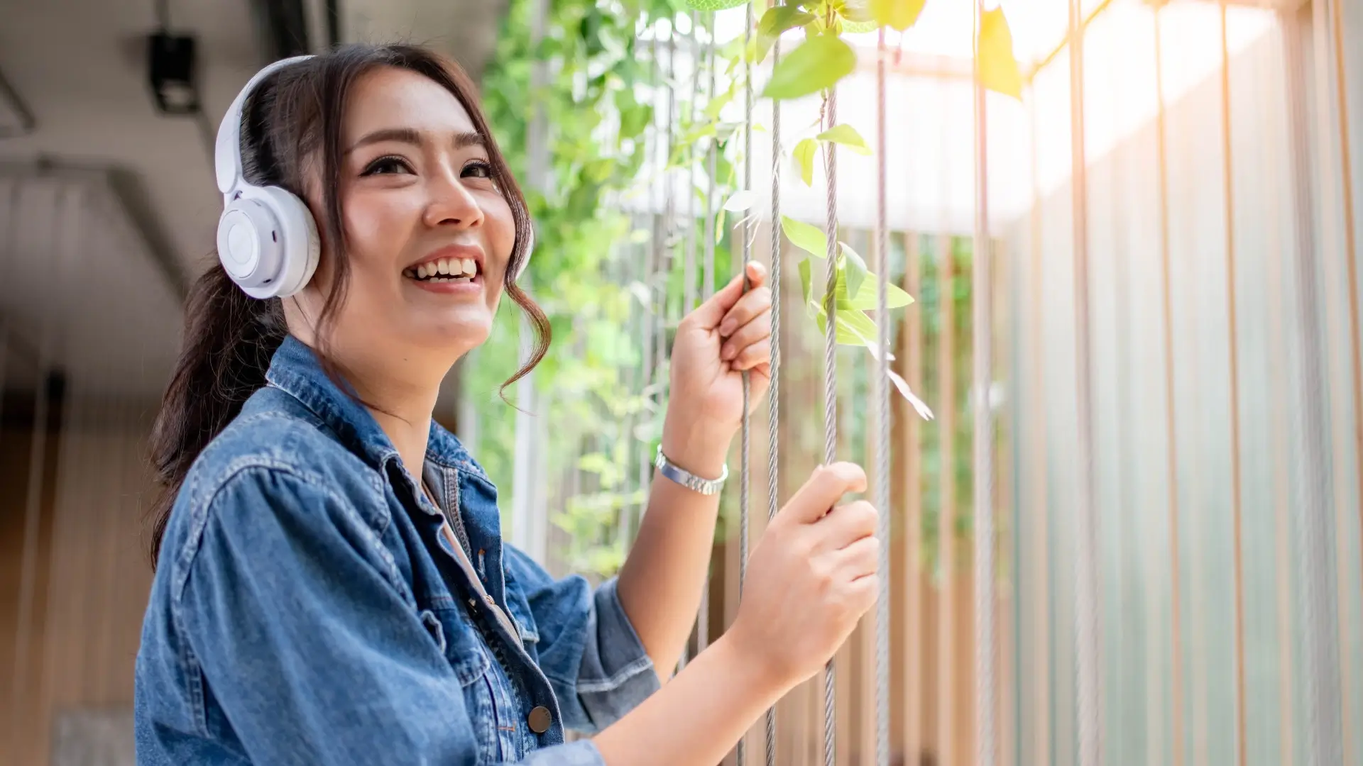 Imagem de uma mulher feliz enquanto escuta música no seu fone de ouvido 