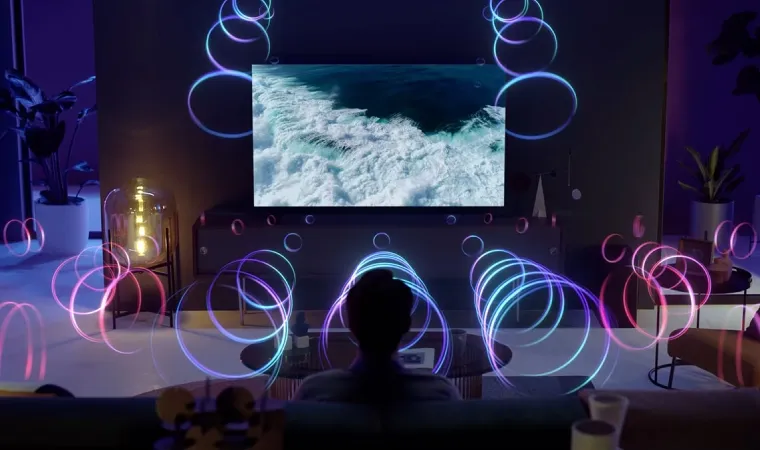 Imagem mostra homem assistindo a uma programação na TV da Samsung e tendo uma experiência sonora completa.