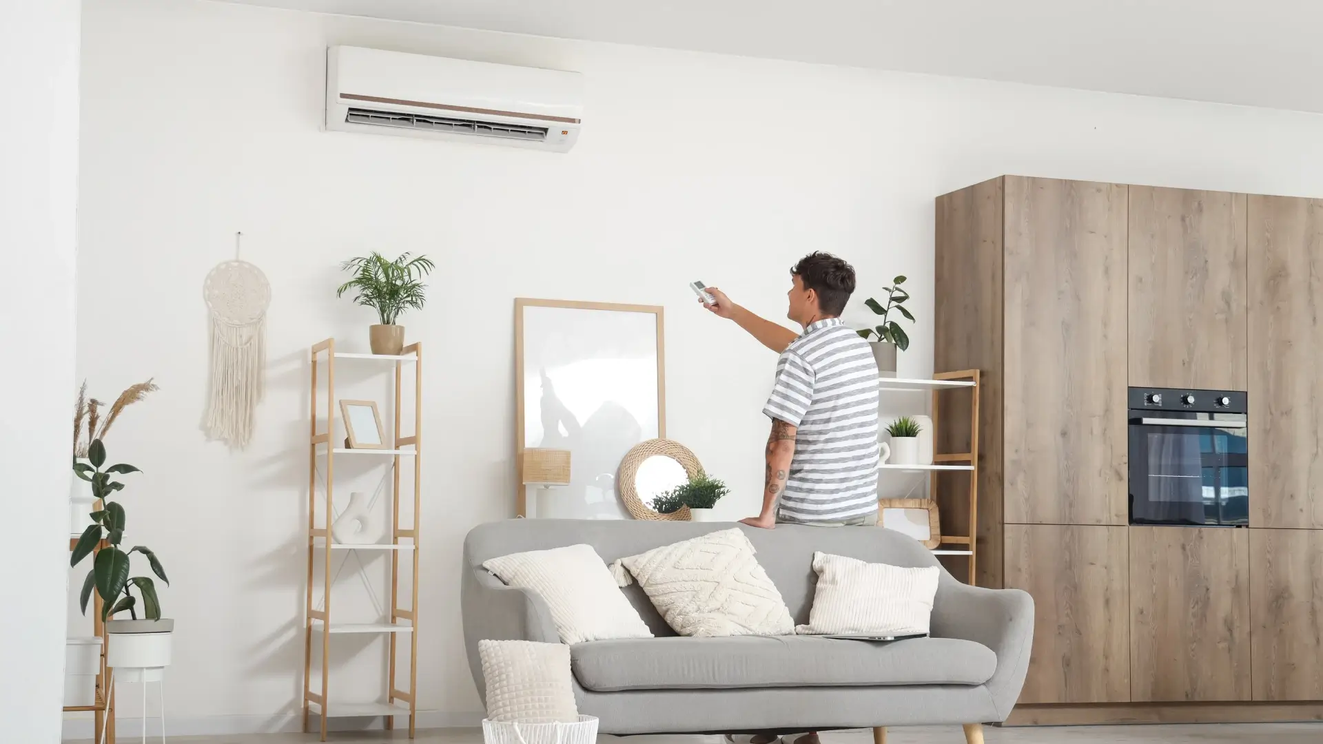 Imagem de um homem apontando o controle remoto para o ar-condicionado