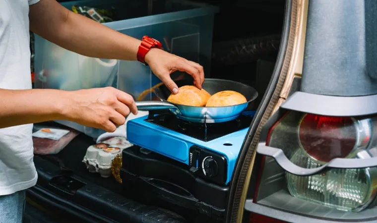 Fogão portátil ligado com uma frigideira em cima.