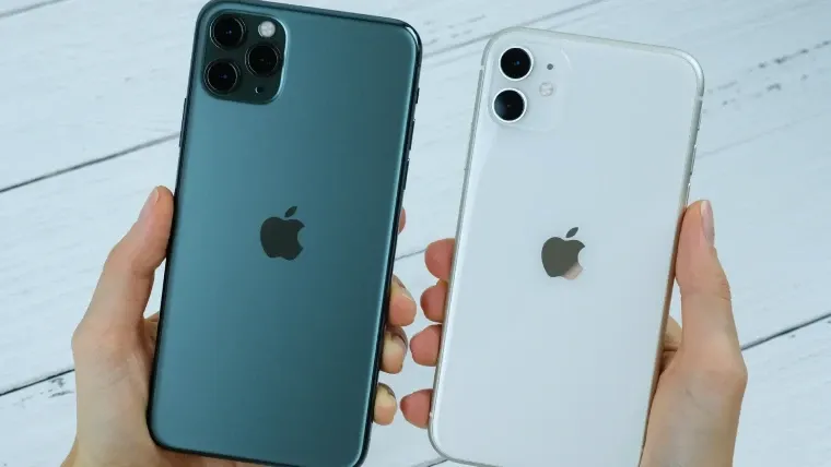 Uma pessoa segura dois celulares, cada um em uma mão. O da esquerda é verde e o da direita é branco