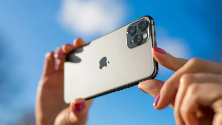 Uma pessoa segura um iPhone 11 na horizontal com as duas mãos