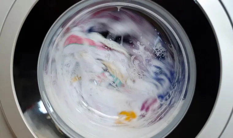 Lava e seca em destaque com roupas centrifugando.