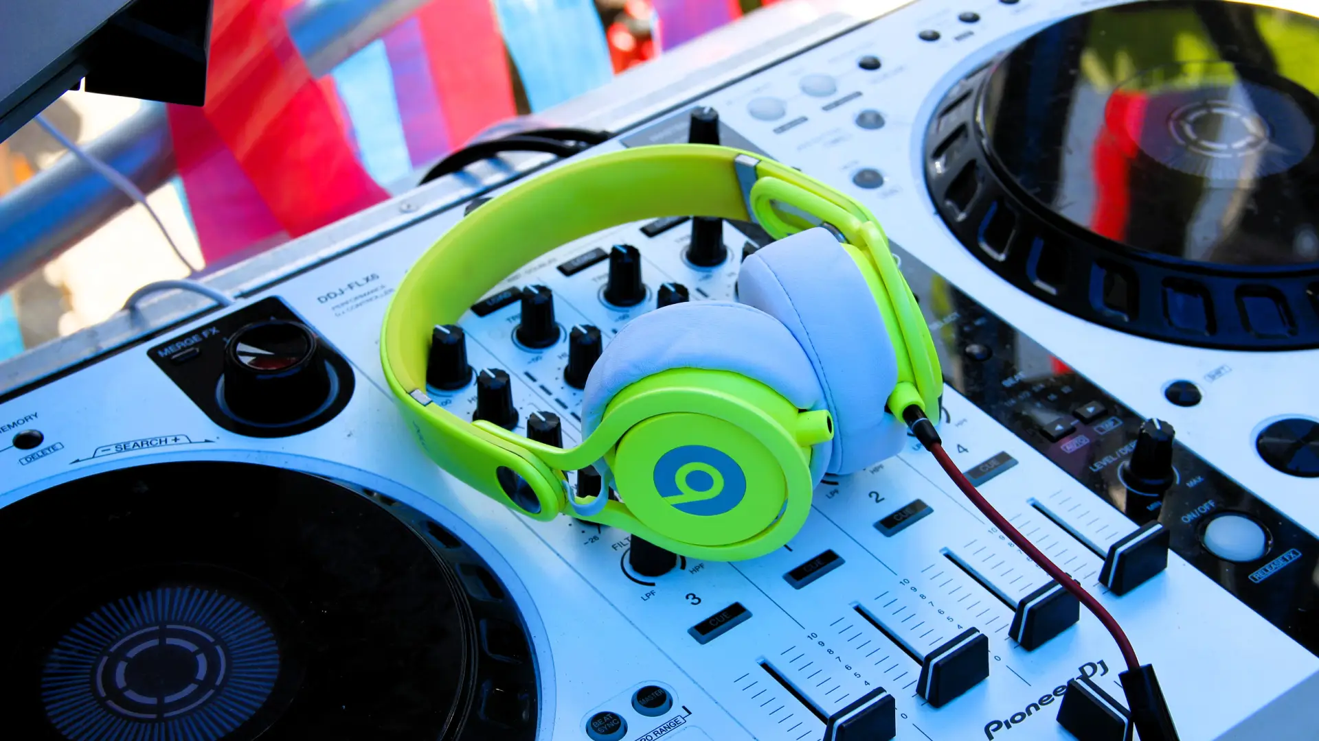 Mesa de DJ com um fone de ouvido Beats verde em cima