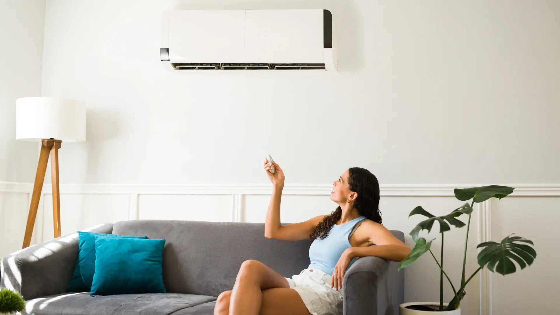 mulher relaxando em sofá se refresca no ar-condicionado split   