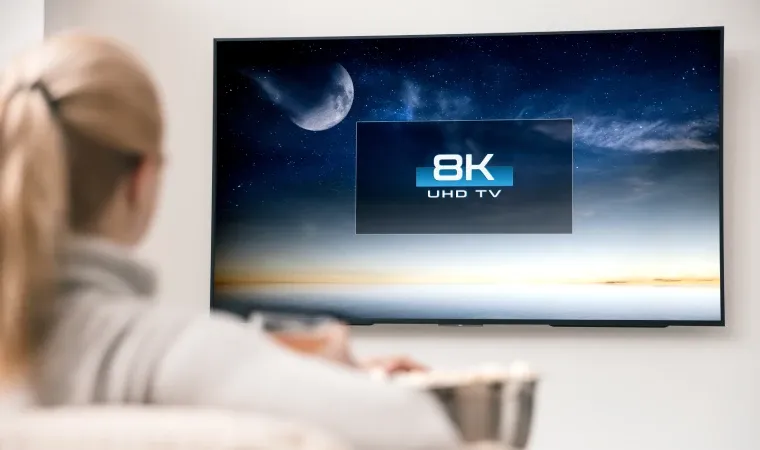 mulher em sua casa assistindo uma TV 8K