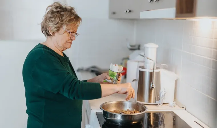 uma mulher cozinhando em um cooktop