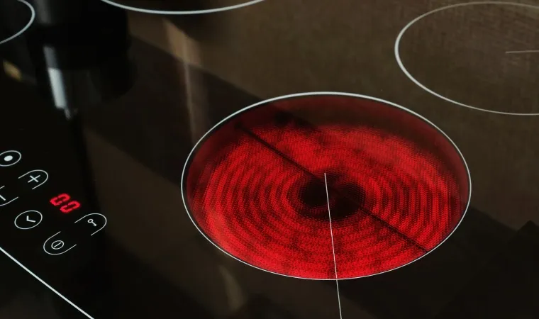 Cooktop de indução com área de calor acesa em destaque.