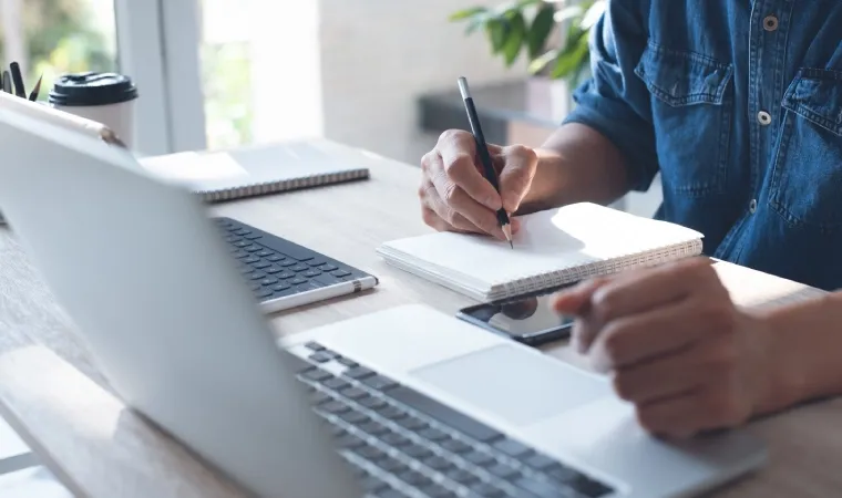 Imagem mostra homem estudando em um notebook para faculdade