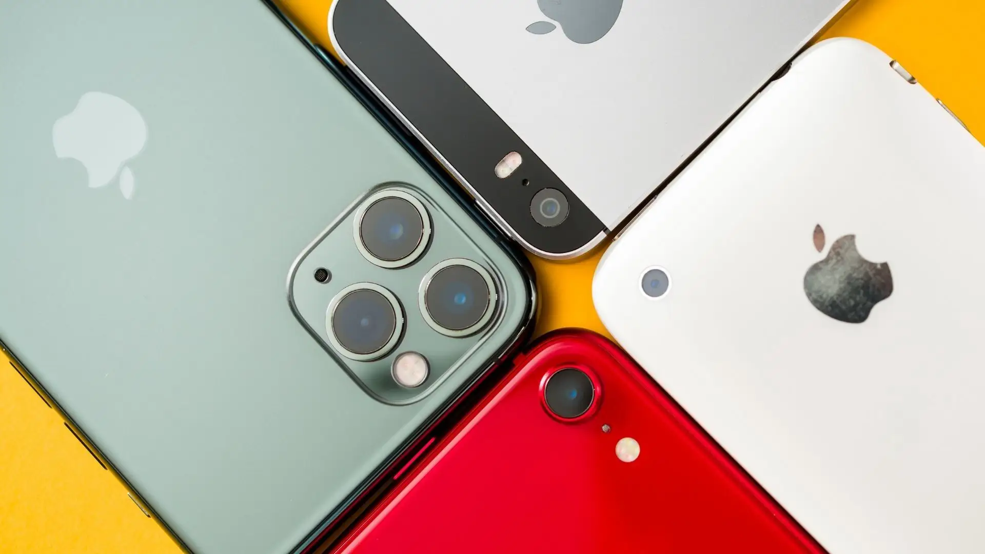 Imagem de quatro iPhones diferentes encostados para destacar a diferença entre gerações  