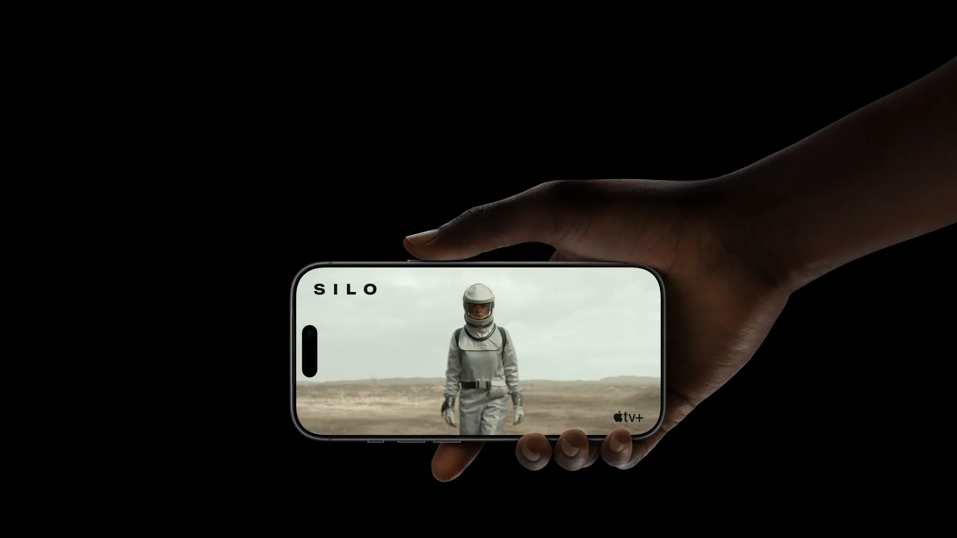 Mão segurando o iPhone 17 Pro Max em modo paisagem, exibindo uma cena da série Silo no Apple TV+ 
