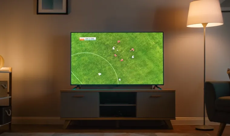 Imagem mostra sala de estar com uma TV Black Friday 2025 transmitindo um jogo de futebol.