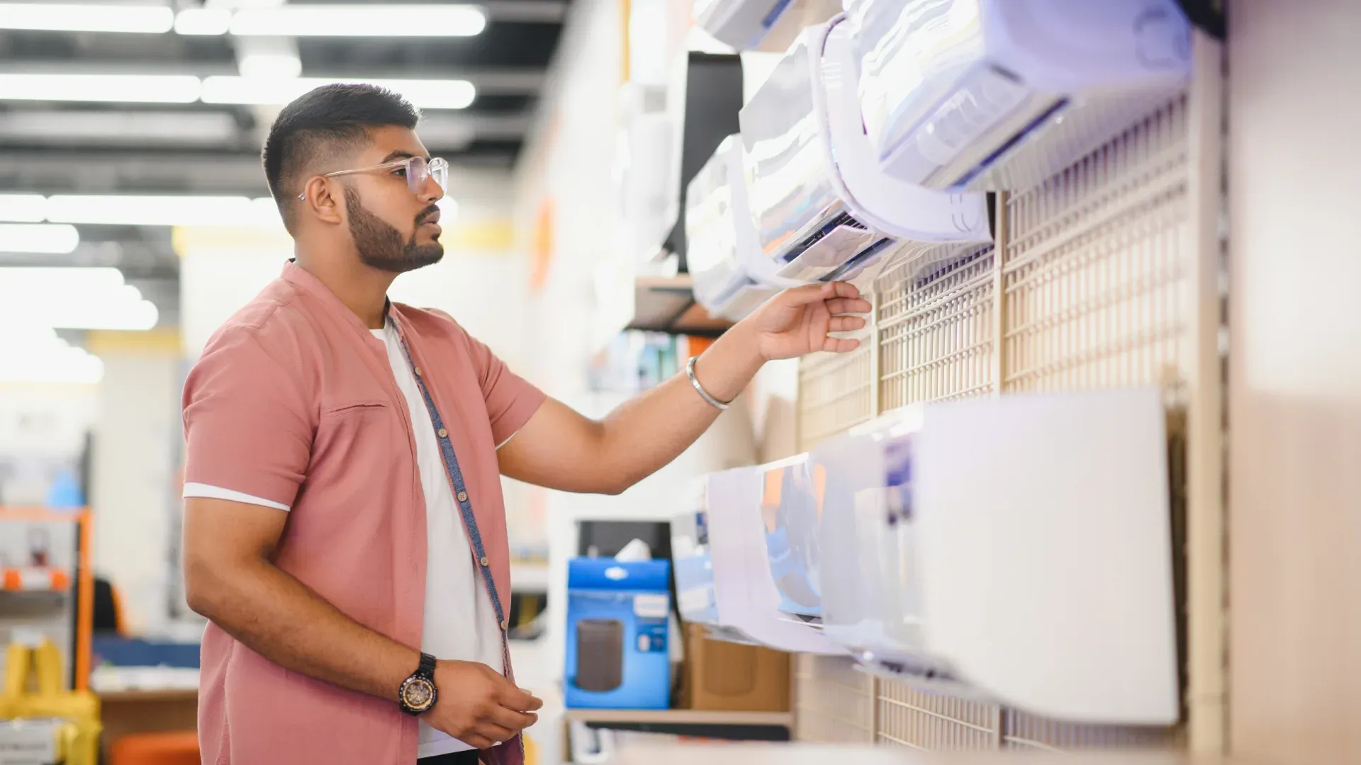 Imagem de um homem escolhendo um ar-condicionado na loja