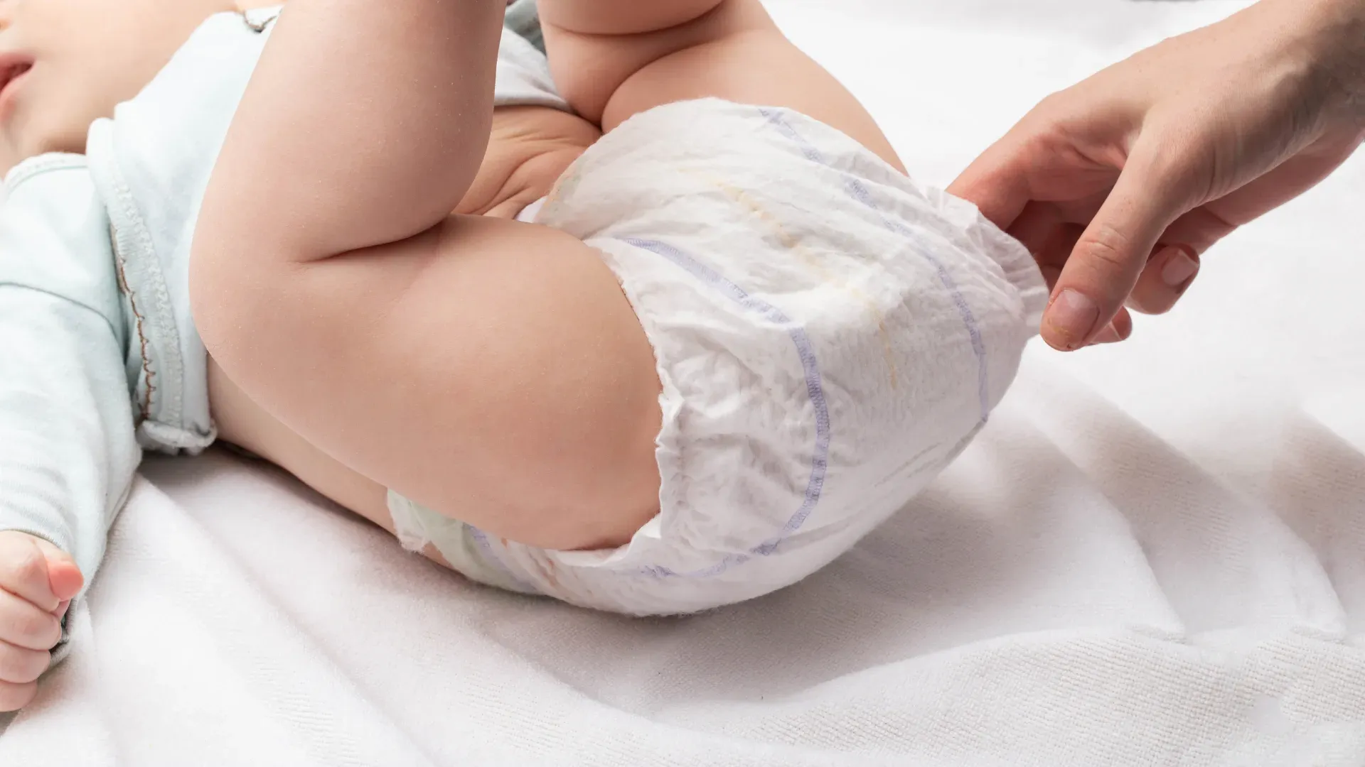 mãe checando fralda de bebê deitado com as pernas para cima