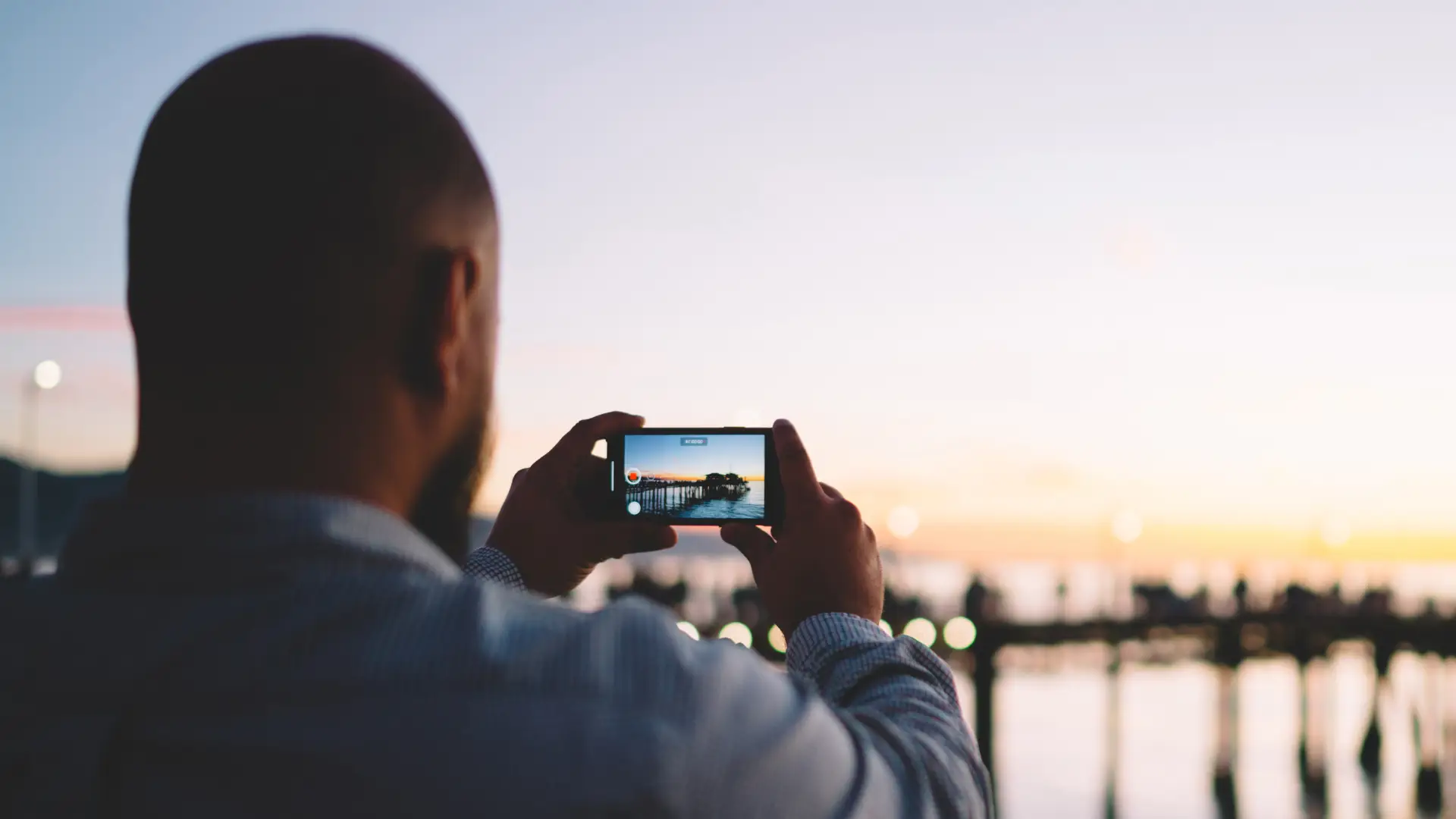 Imagem de um homem usando um celular para tirar foto