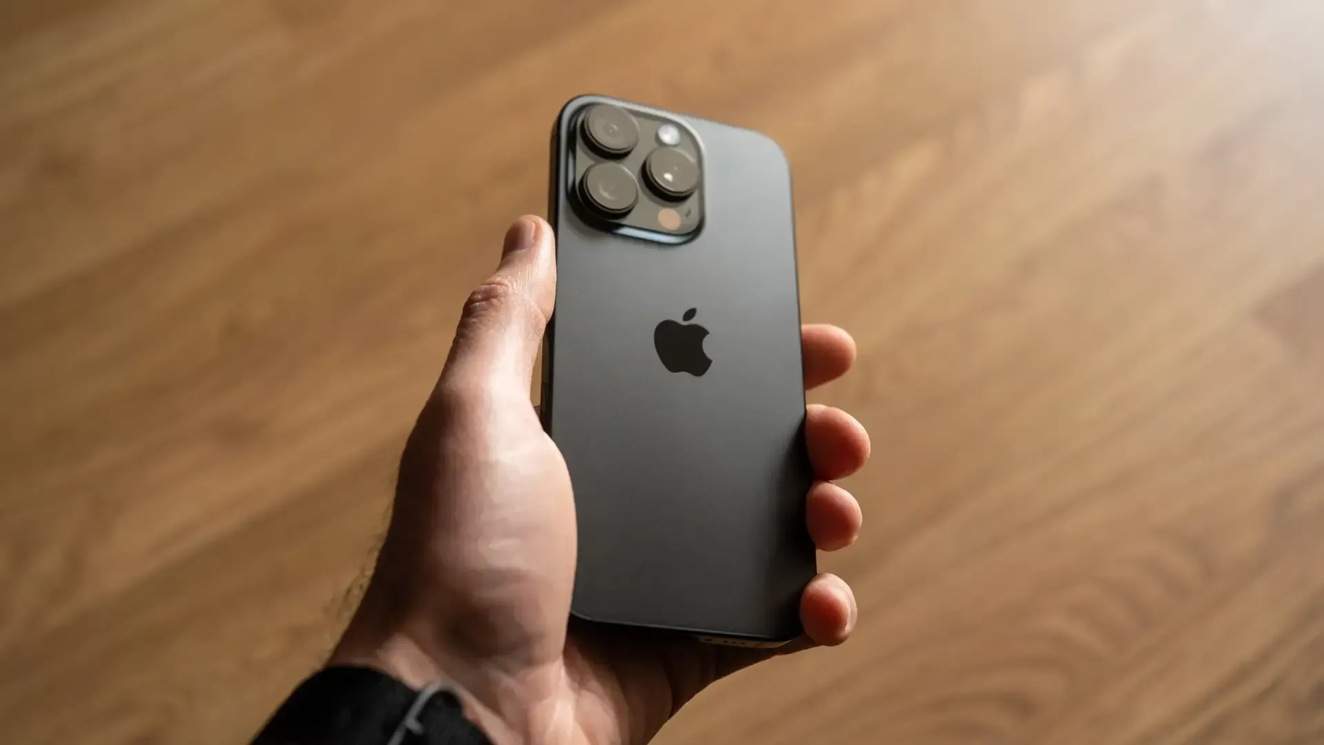 Imagem de uma pessoa segurando um iPhone com a parte traseira virada para cima