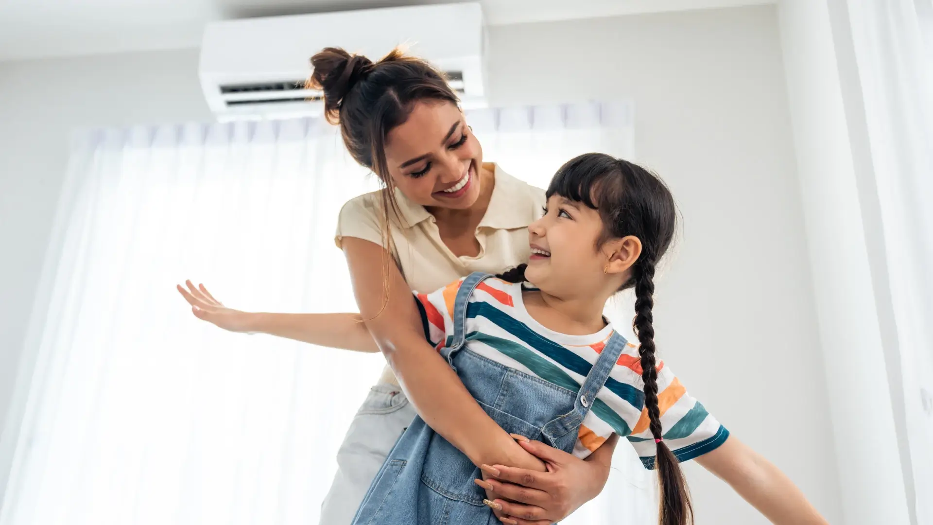 Mãe e filha felizes aproveitando o ar-condicionado instalado