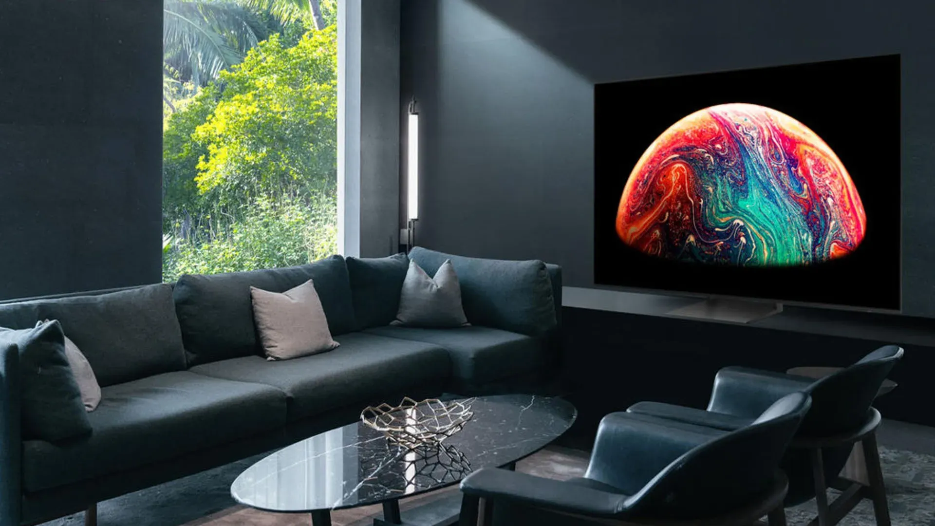 Imagem da TV Samsung OLED S90C em sala moderna exibindo interface do Tizen Smart Hub com aplicativos de streaming na tela.