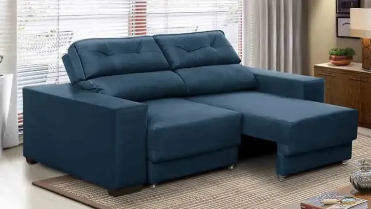 Sofá retrátil e reclinável na cor azul marinho em sala de janela ampla com persianas brancas.