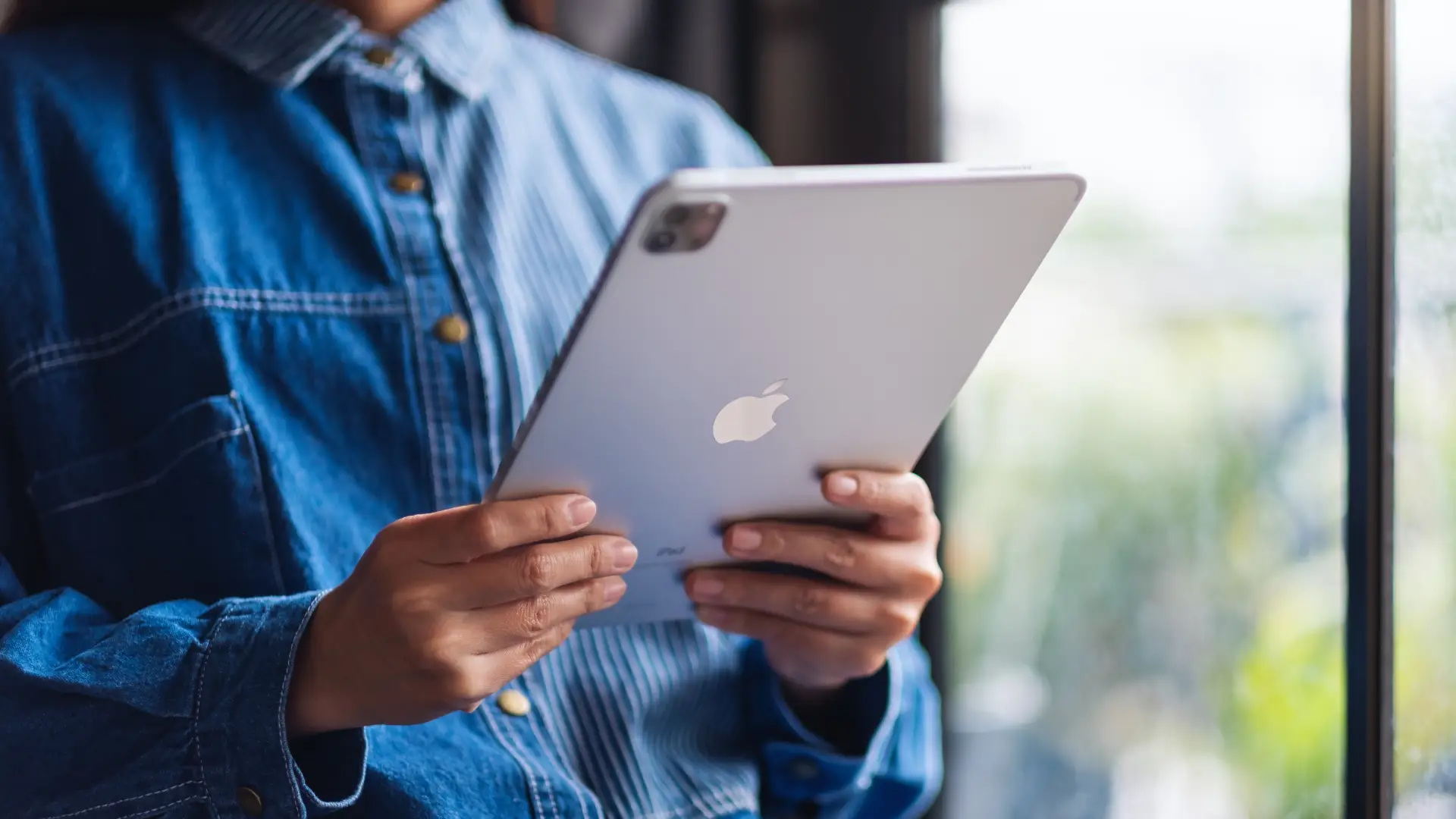 Imagem de uma pessoa segurando um tablet iPad