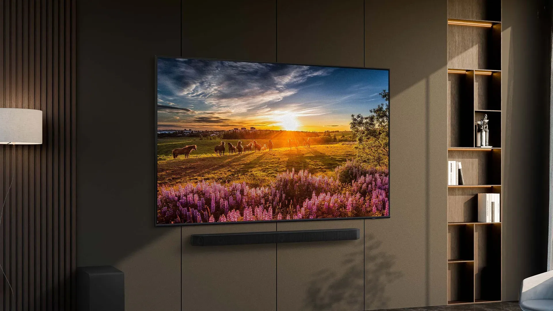 Imagem da TV Samsung Q65D 55” QLED 4K montada em parede de sala sofisticada, com iluminação suave e base discreta. 