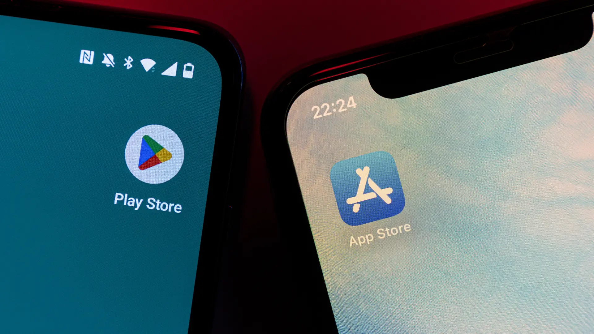 Dois celulares estão lado a lado mostrando o Google Play e a App Store