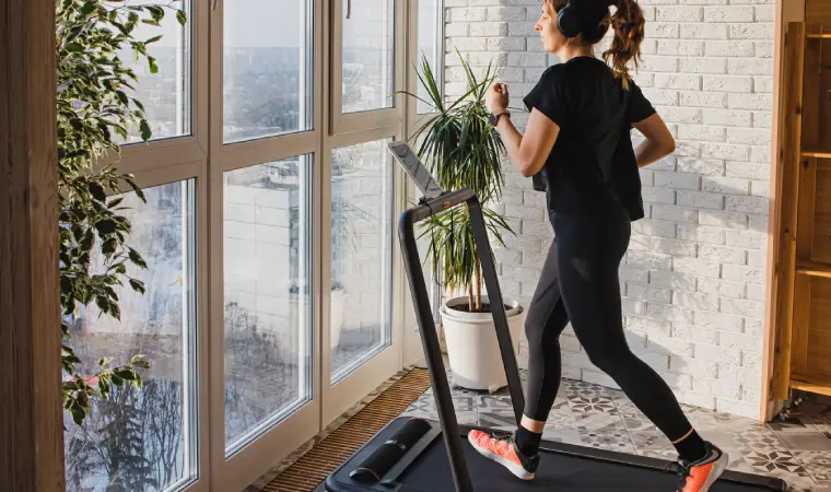 Mulher correndo em uma esteira ergométrica em sua sala